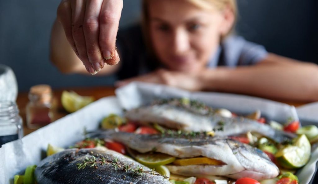 Donna con pesce a tavola