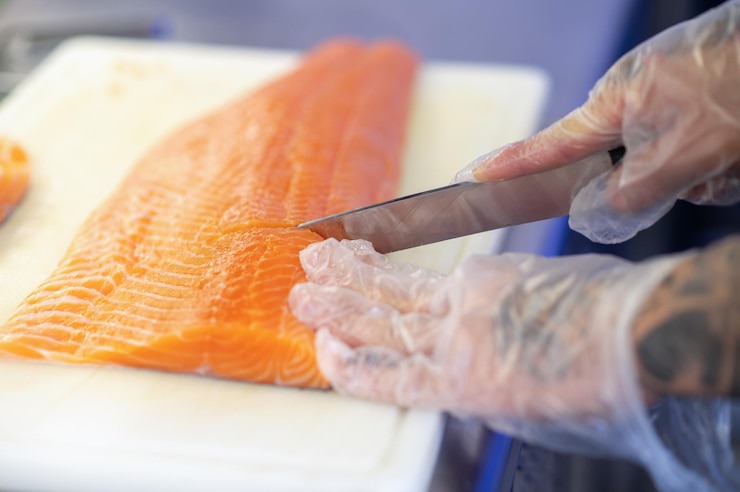 Persona che taglia salmone