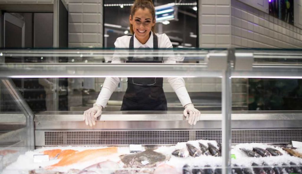 Donna dietro al bancone del pesce