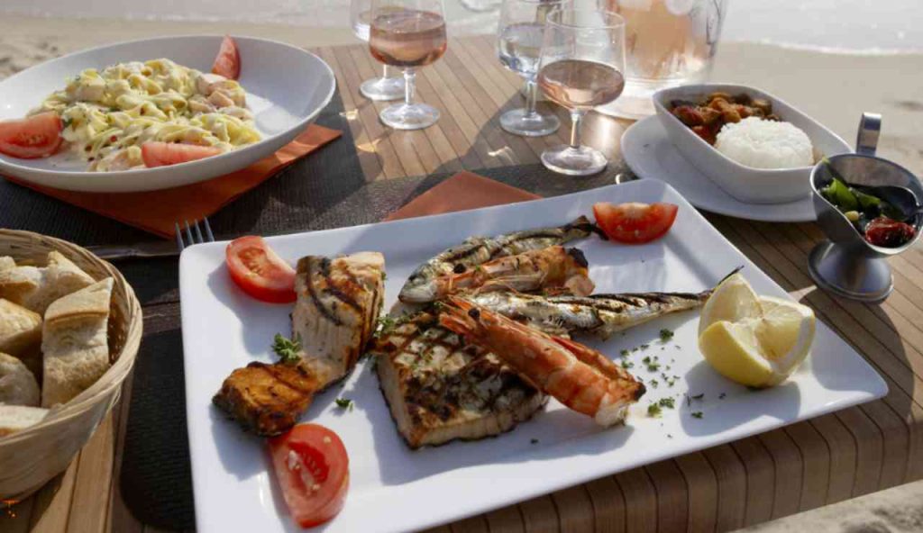 Illustrazione del pranzo di Ferragosto (Canva FOTO) - marinecue.it