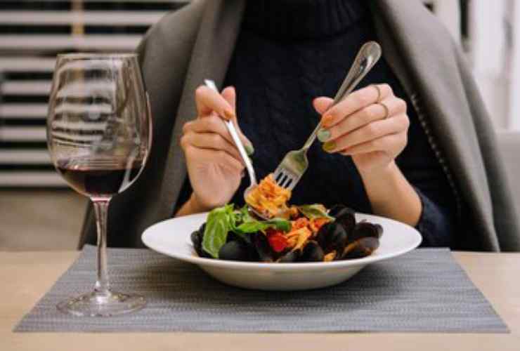 Uomo che mangia cozze