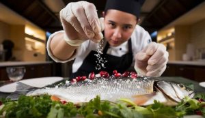 Donna che cucina pesce